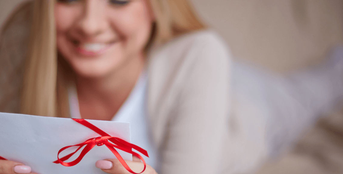 Woman smiling while reading gift message